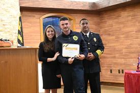 Aaron Combs, flanked by Instructors Jodi Truesdell and Alejandro Valazquez, receives the award for Excellence in Action. 